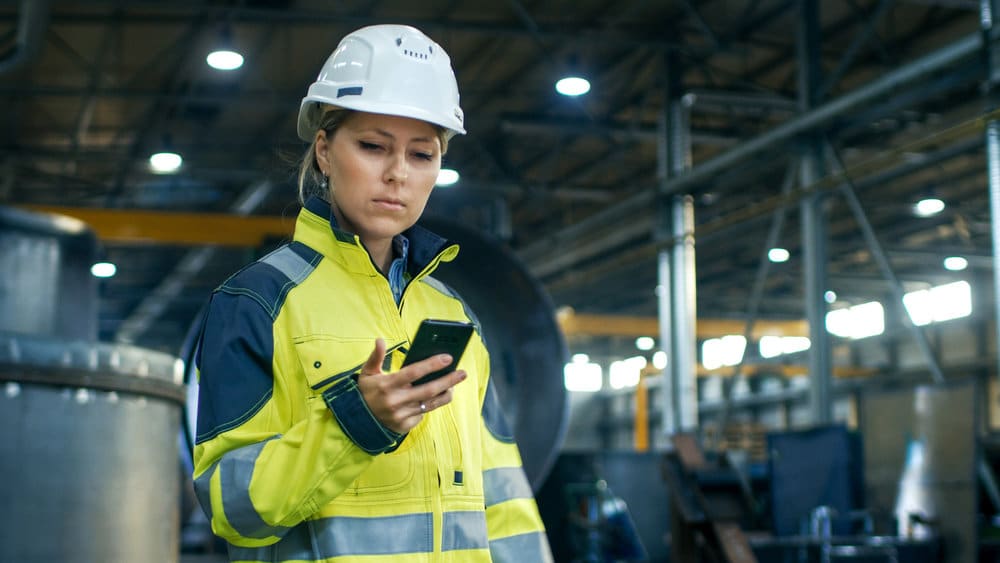 Industrial Worker Looking At Her Scheduling App