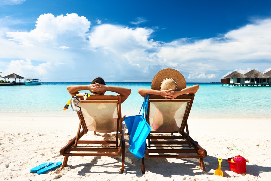 A Couple Sitting On a Beach While On Vacation