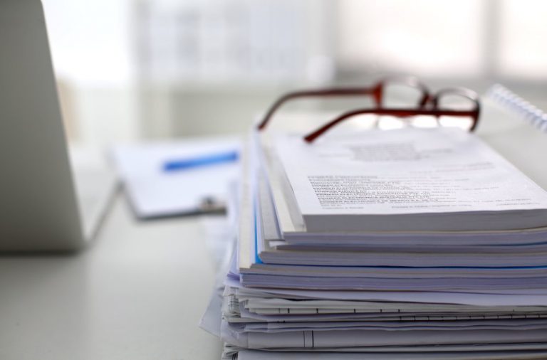 A Pair of Glasses Sitting on a Stack of Papers