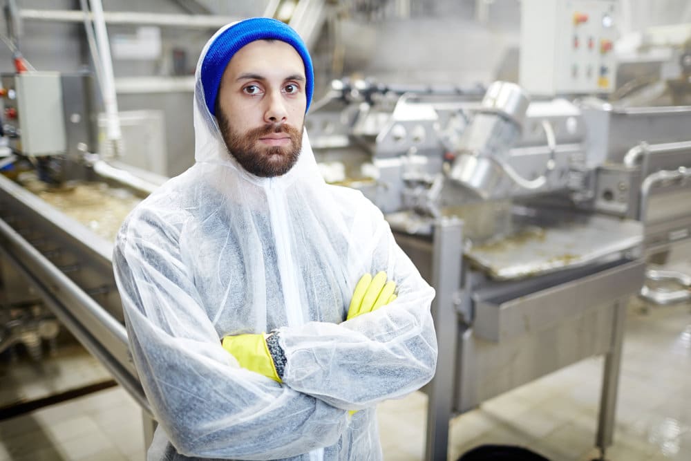 Industrial Worker Standing Next To Machinery