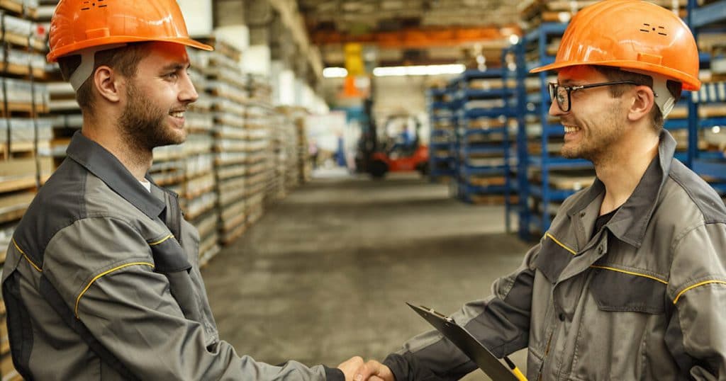 Two Manufacturing Workers Shaking Hands