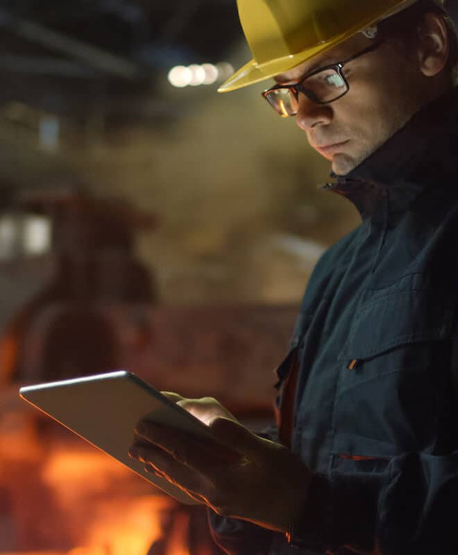 Engineer Wearing a Hardhat on a Tablet in a Factory