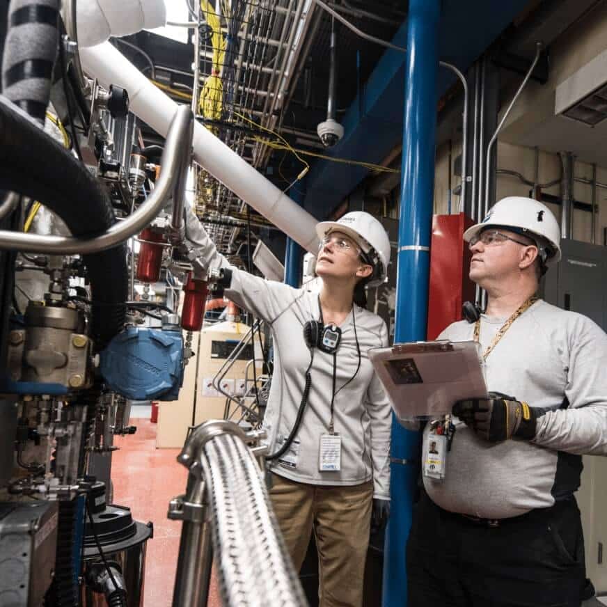 Two Factory Workers Analyzing Machines