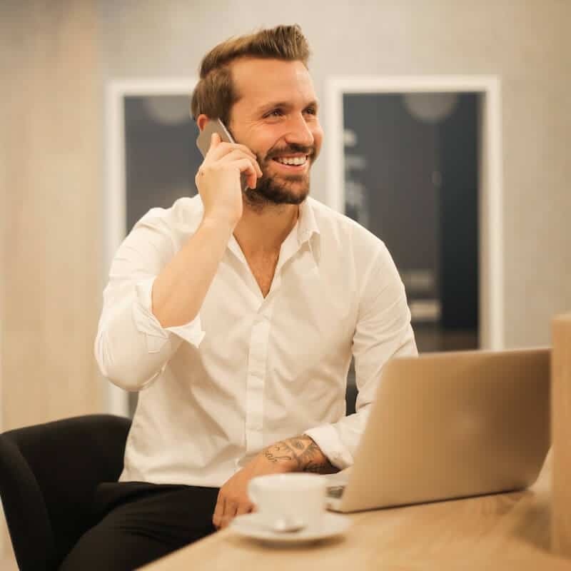 Male Businessman on the Phone with a Laptop in Front of Him