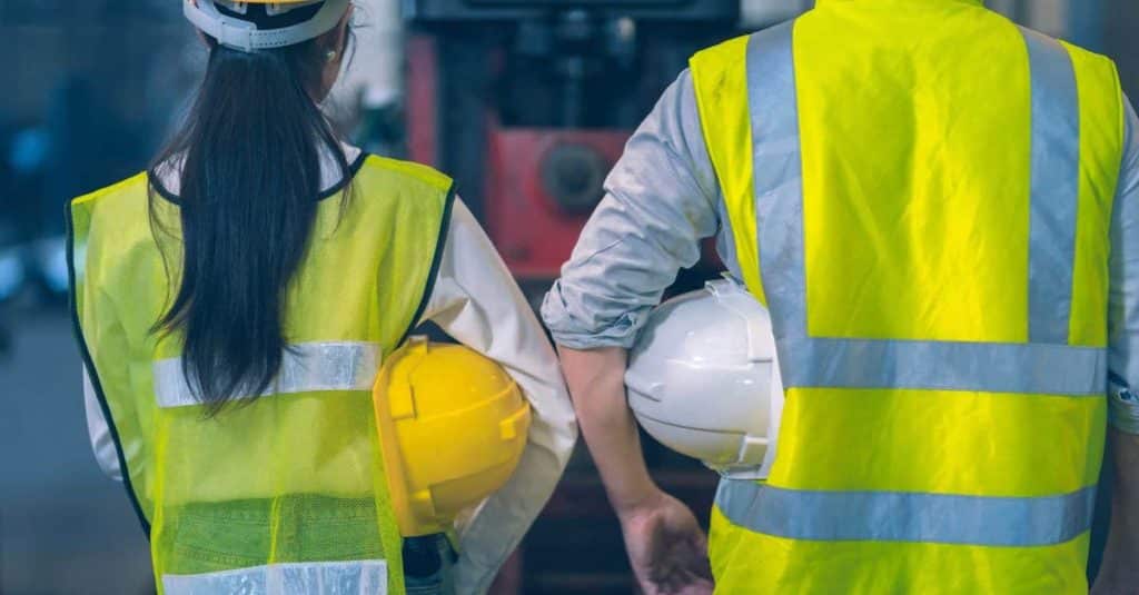 The behind of Engineer white and yellow safety hat wear the Safety Reflective Vest.