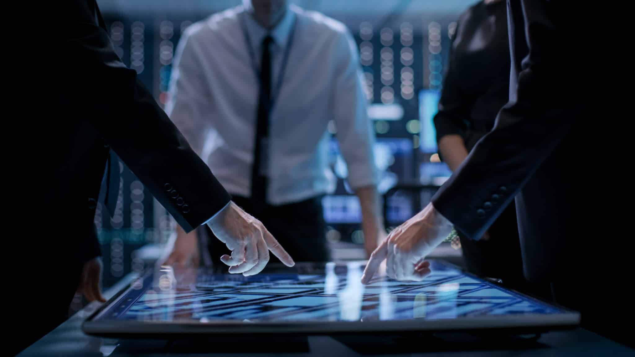 Corporate,managers,working,at,the,table,in,monitoring,room.,room