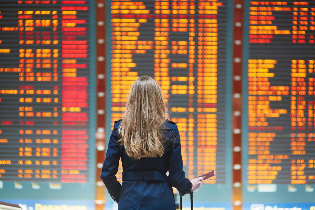 Young,woman,in,international,airport,looking,at,the,flight,information, Aviation Scheduling Software