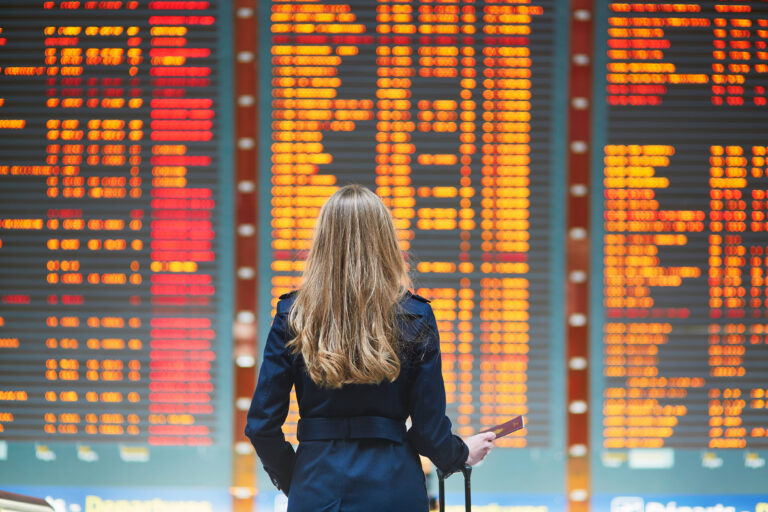 Young,woman,in,international,airport,looking,at,the,flight,information, Aviation Scheduling Software