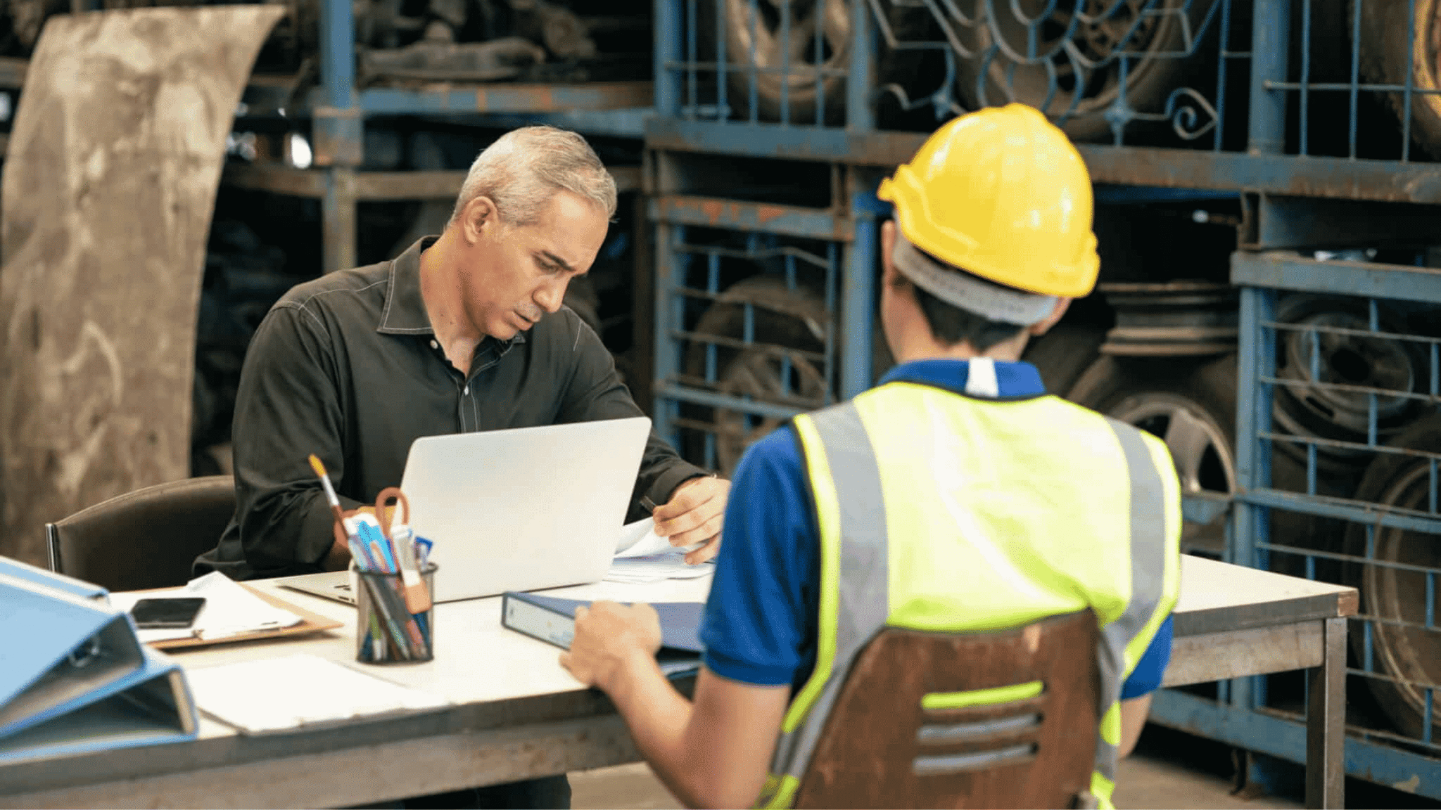 Factory,manager,looking,at,the,paper,with,young,engineer,sitting, Employee Turnover
