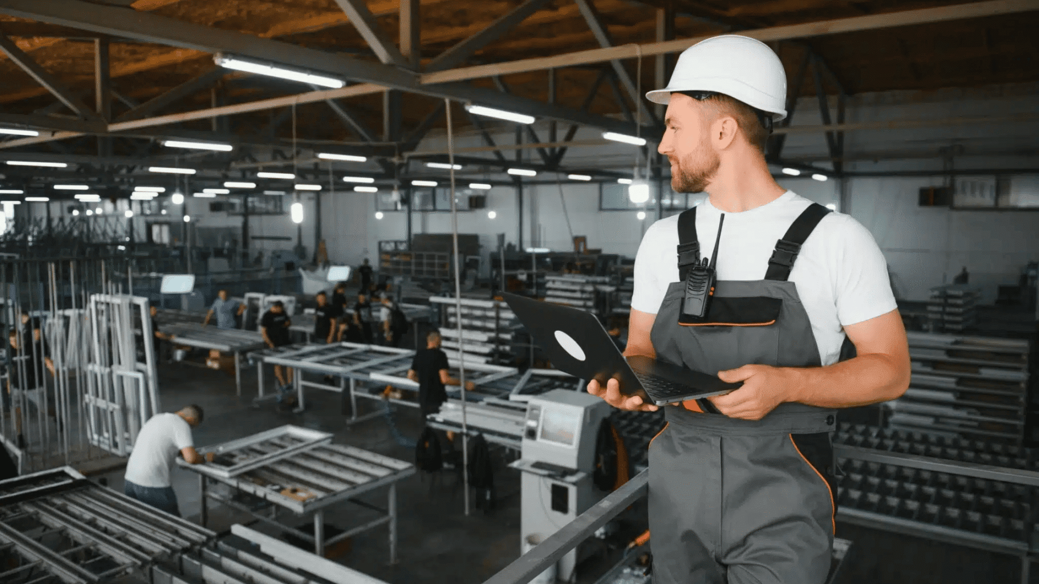 Contract Manufacturing Organization 1 Person Close Up With Laptop Dozens Of People On Factory Floor