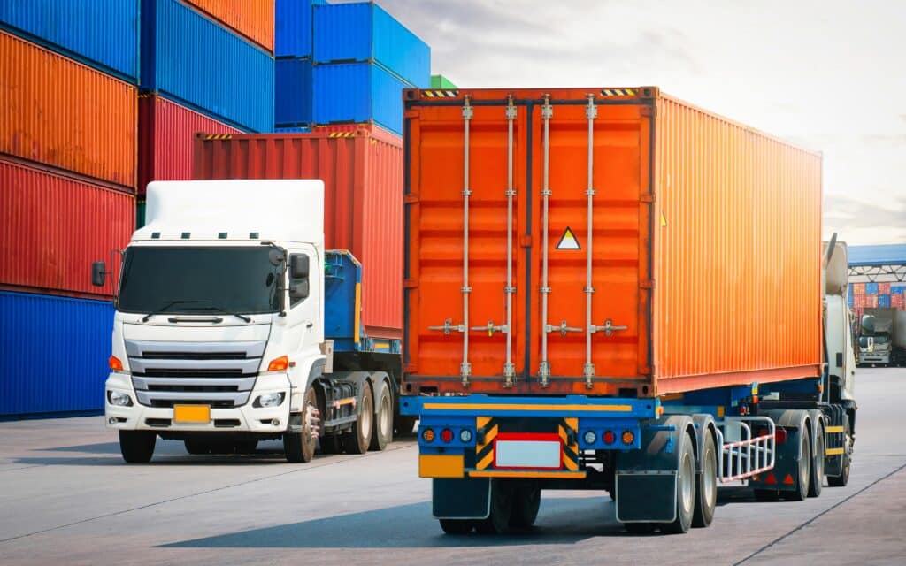 Semi,trailer,trucks,on,the,road,and,stacked,of,containers,freight forwarding
