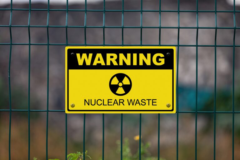 black and yellow warning nuclear waste sign on fence