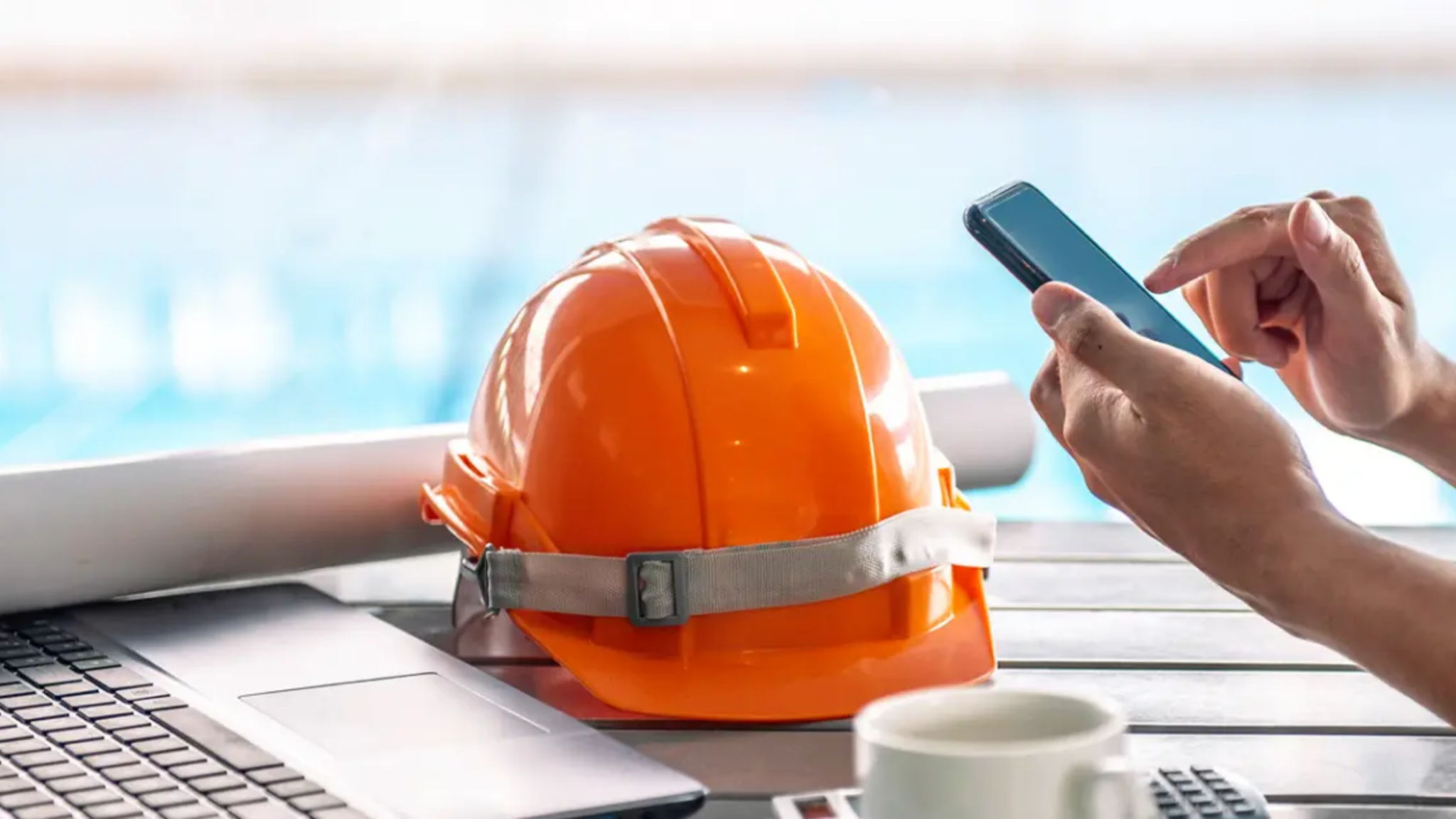 An, Orange, Construction, Helmet, Laptop, Coffee, And, Person, Holding, A, Phone