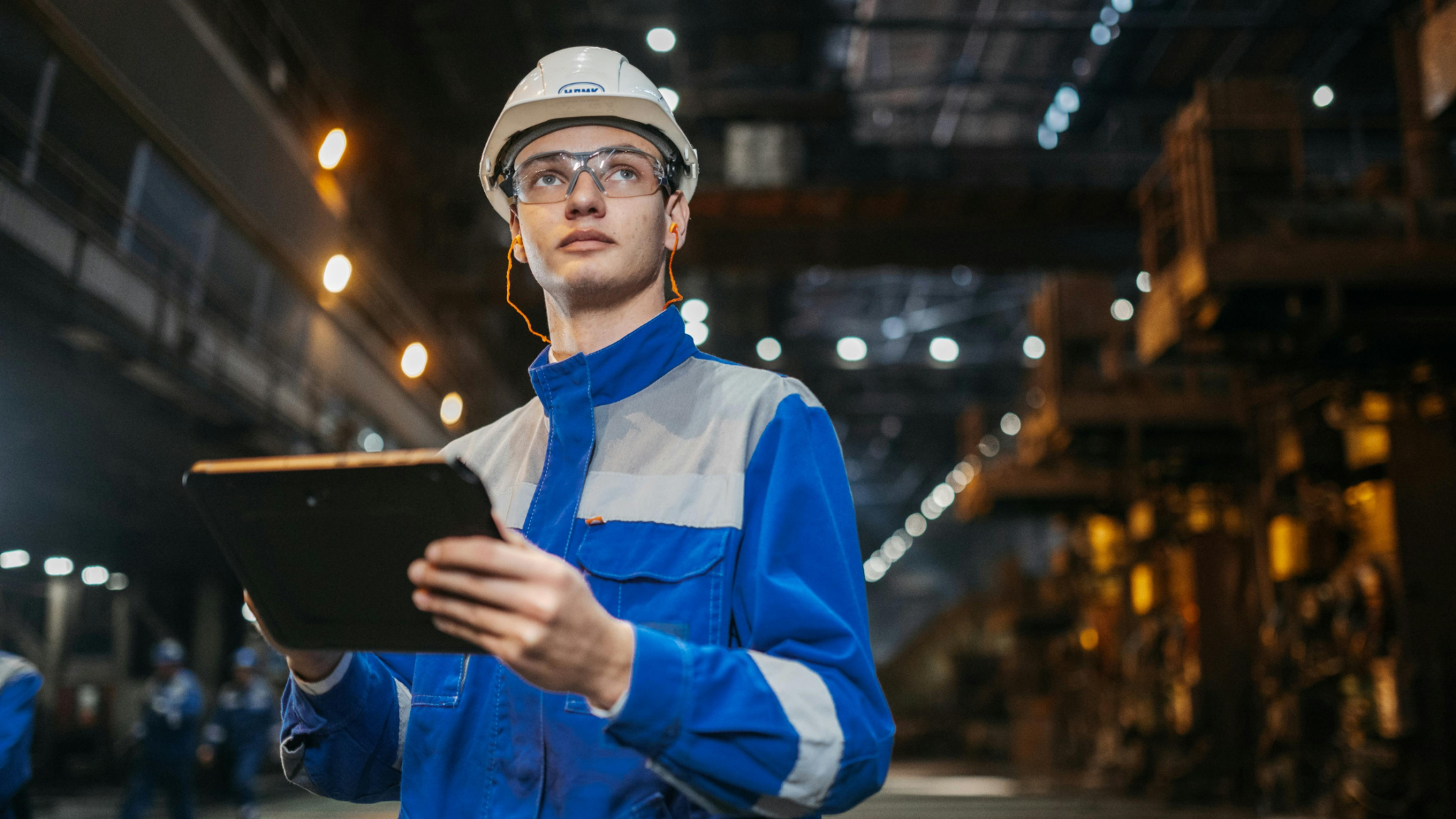 Industrial, Work, Environment, With, Engineer, In, Blue, And, White, Ppe, Holding, An, Ipad