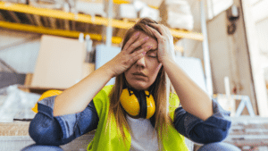 Stressed Out Female Manufacturing Employee In High Vis Toxic Work Culture